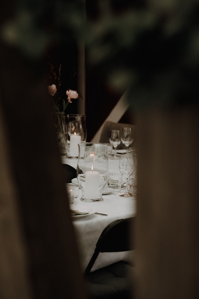 Table setting with candles and glasses for an event.